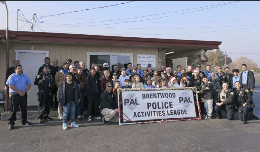 Officers from Brentwood Pal taking a group picture with kids during their Shop with a Cop event.