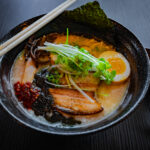 ramen in bowl with chopsticks and spoon