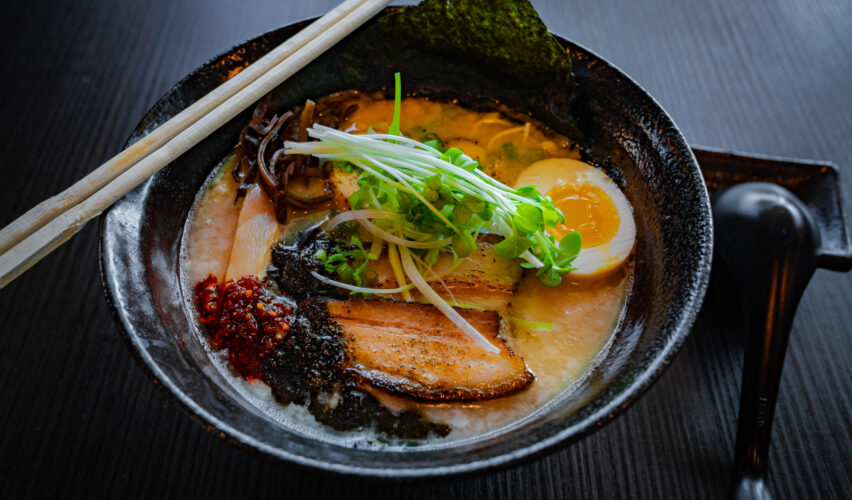ramen in bowl with chopsticks and spoon